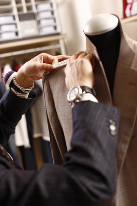 master tailor in Hoi An correcting shoulder imbalance on a custom suit